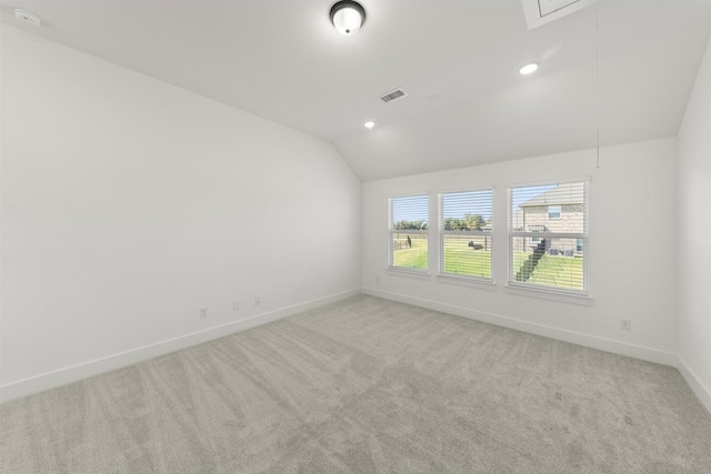 spare room featuring lofted ceiling and light carpet