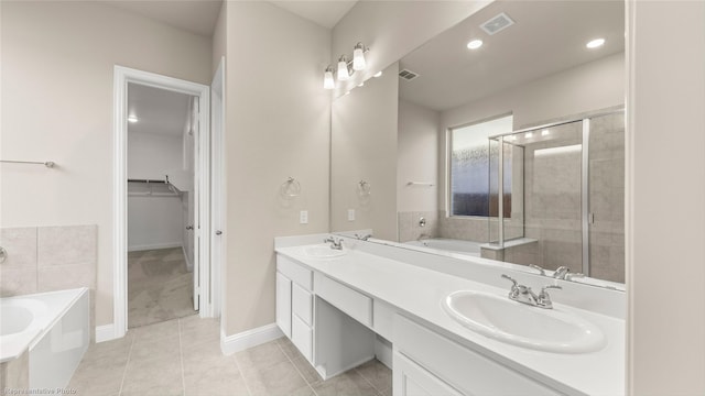 bathroom with tile patterned flooring, independent shower and bath, and vanity