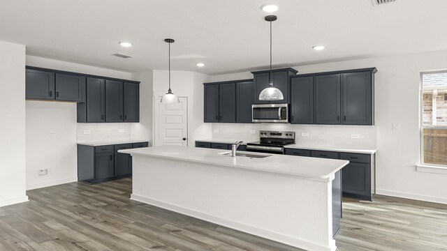 kitchen with a healthy amount of sunlight, white cabinetry, an island with sink, and stainless steel appliances