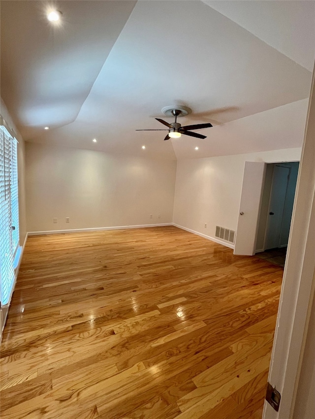 spare room with light hardwood / wood-style flooring, lofted ceiling, and ceiling fan