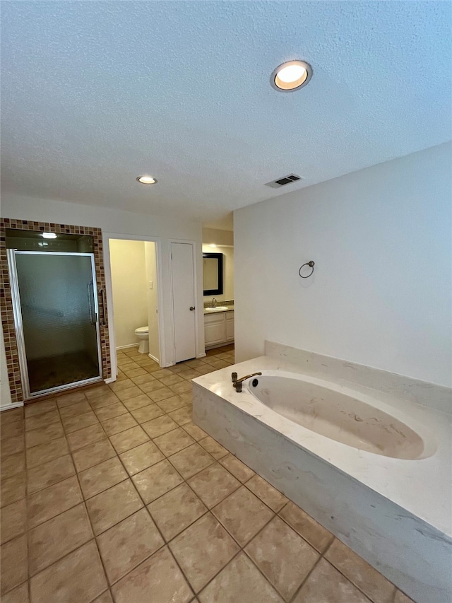 full bathroom with shower with separate bathtub, a textured ceiling, tile patterned floors, vanity, and toilet