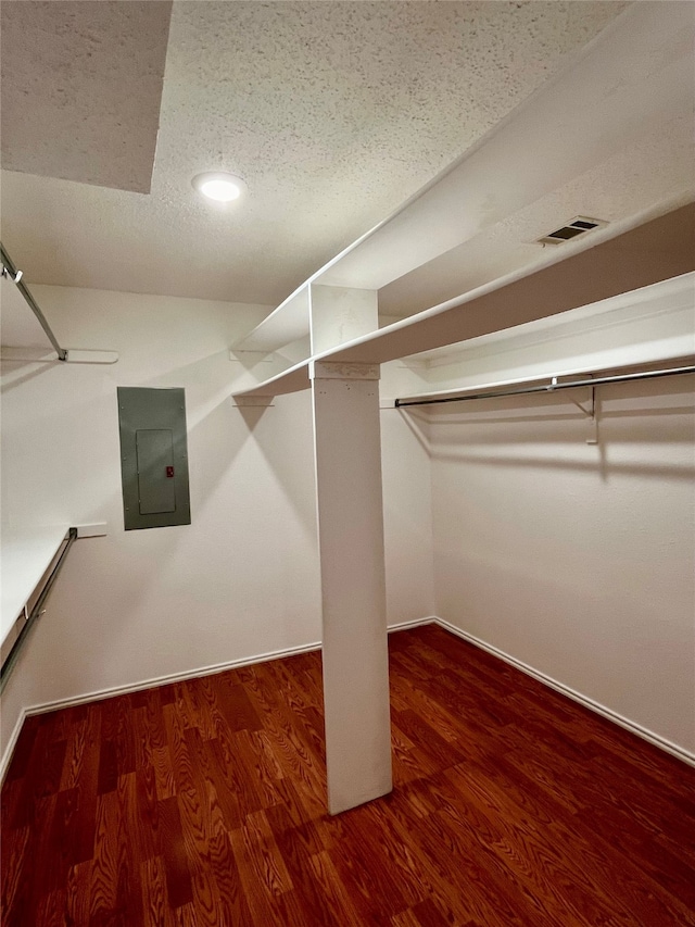 spacious closet featuring dark hardwood / wood-style floors and electric panel