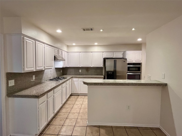 kitchen with white cabinetry, kitchen peninsula, decorative backsplash, stainless steel appliances, and light tile patterned floors