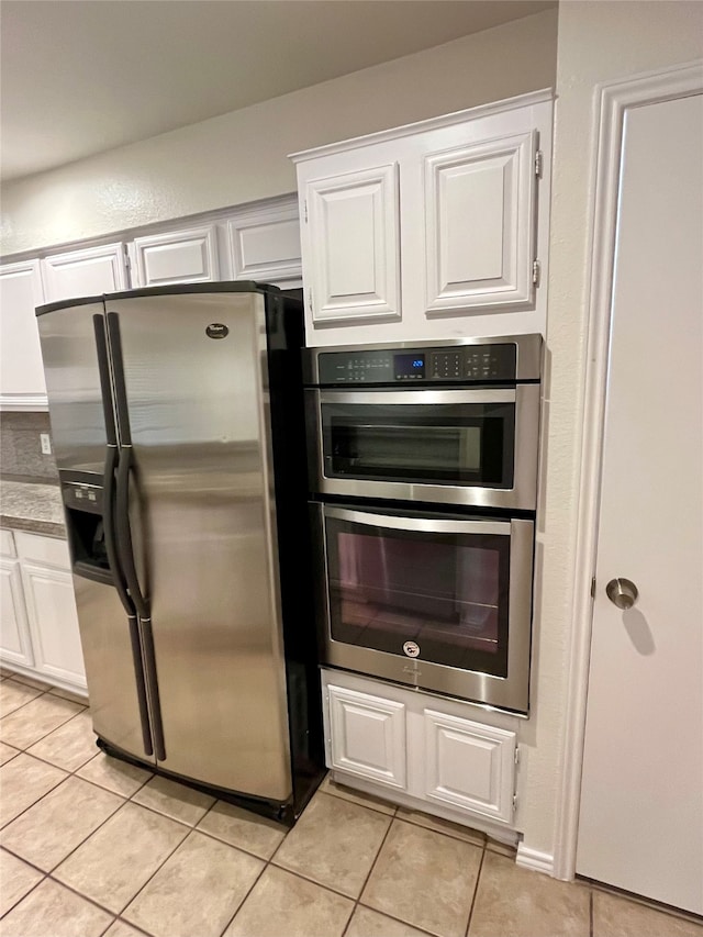 kitchen featuring stainless steel appliances, white cabinets, and light tile patterned flooring