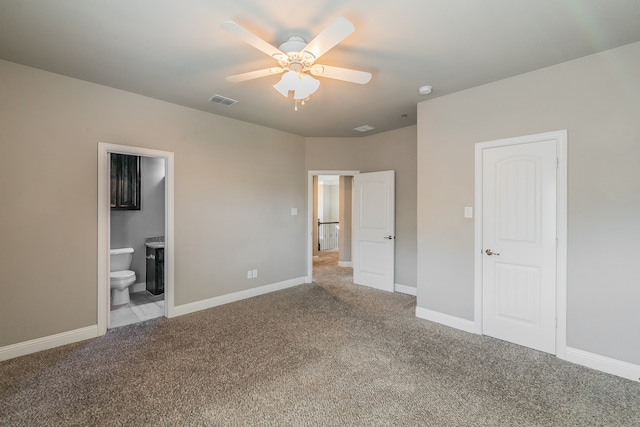 unfurnished bedroom with ceiling fan, light carpet, ensuite bathroom, and a closet