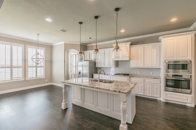 kitchen with a breakfast bar, light stone counters, a kitchen island with sink, stainless steel appliances, and dark hardwood / wood-style flooring