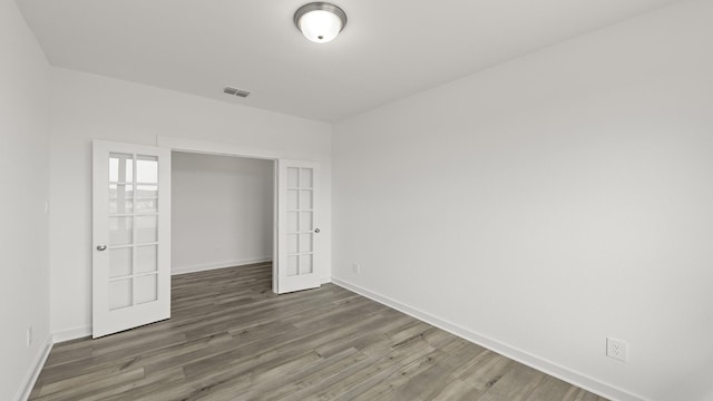 unfurnished bedroom with dark hardwood / wood-style floors and french doors