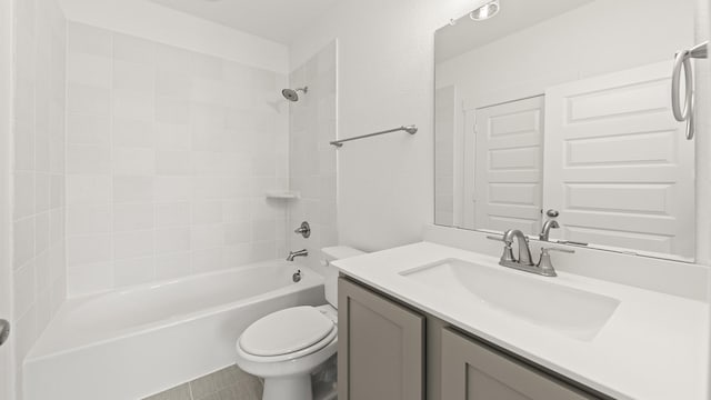 full bathroom with tiled shower / bath, vanity, and toilet