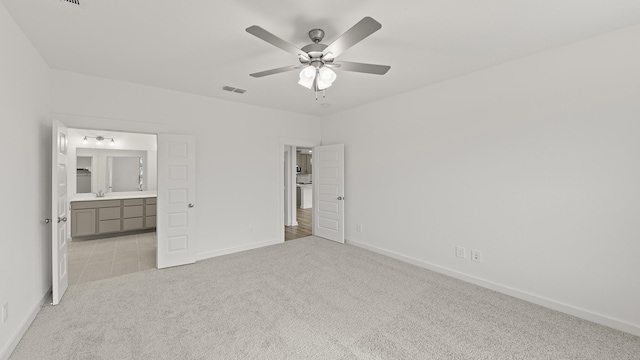 unfurnished bedroom with light carpet, ceiling fan, and ensuite bathroom