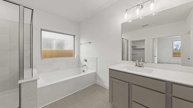 bathroom with tile patterned floors, vanity, and plus walk in shower