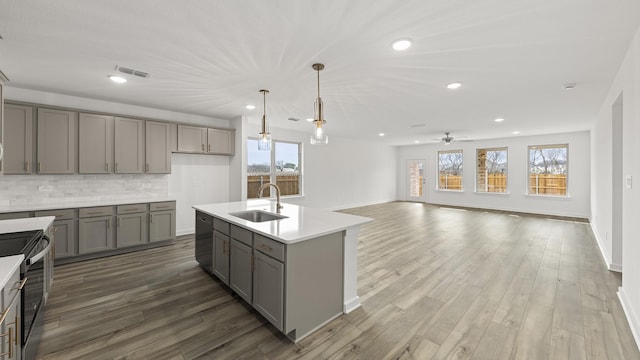 kitchen featuring pendant lighting, sink, gray cabinets, electric range, and decorative backsplash