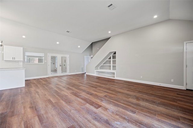 unfurnished living room with wood-type flooring and lofted ceiling