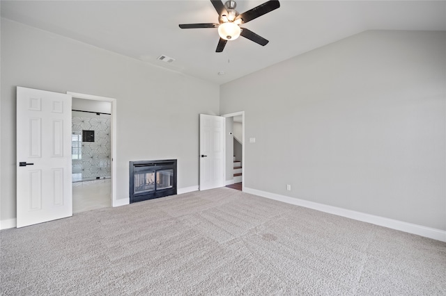 unfurnished bedroom featuring connected bathroom, carpet flooring, vaulted ceiling, and ceiling fan