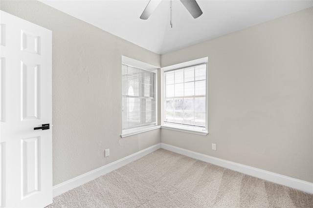 carpeted spare room with lofted ceiling and ceiling fan