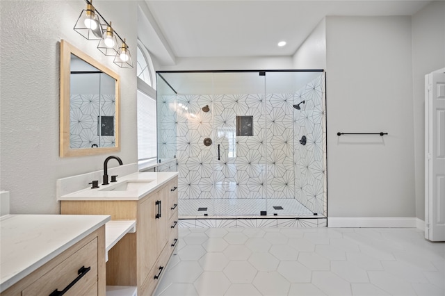 bathroom featuring a tile shower, vanity, and tile patterned floors