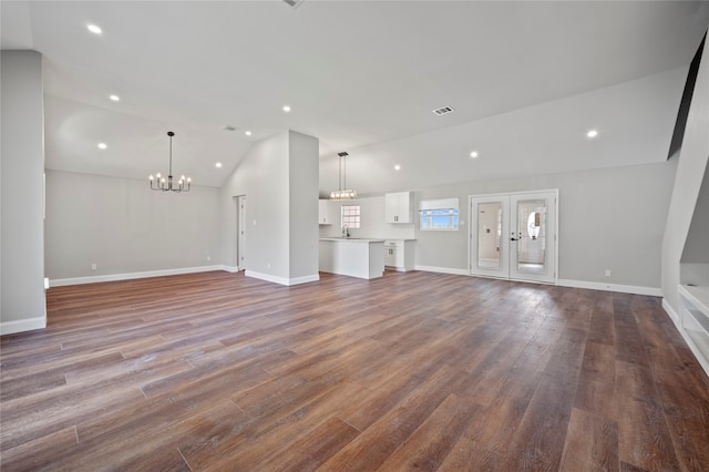 unfurnished living room featuring lofted ceiling, hardwood / wood-style floors, a chandelier, and sink