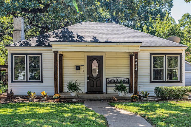 view of front of property with covered porch and a front yard