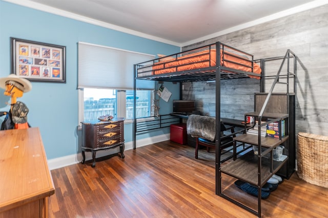 bedroom with dark hardwood / wood-style floors, wood walls, and crown molding