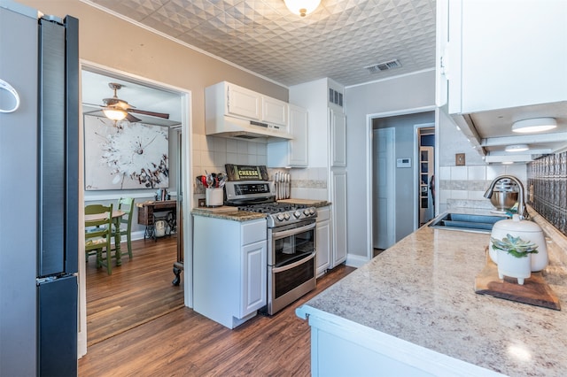 kitchen featuring decorative backsplash, stainless steel appliances, sink, dark hardwood / wood-style floors, and white cabinetry