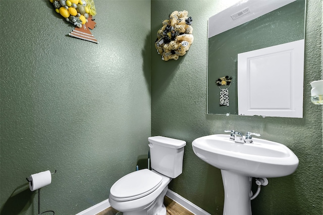 bathroom featuring hardwood / wood-style flooring and toilet