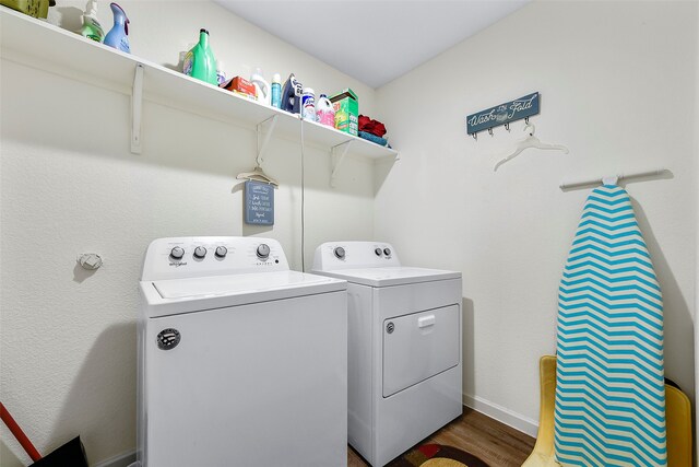 clothes washing area featuring separate washer and dryer and dark hardwood / wood-style floors