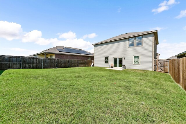 rear view of house featuring a lawn and a patio