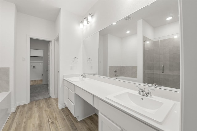 bathroom featuring vanity, hardwood / wood-style flooring, and separate shower and tub