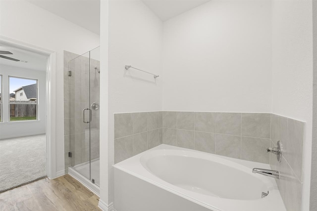 bathroom featuring wood-type flooring and plus walk in shower