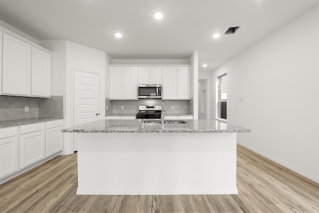 kitchen with white cabinets, sink, a kitchen island with sink, and appliances with stainless steel finishes