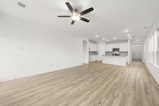 unfurnished living room with light hardwood / wood-style flooring and ceiling fan