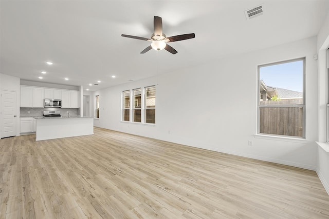 unfurnished living room featuring light wood-type flooring and ceiling fan