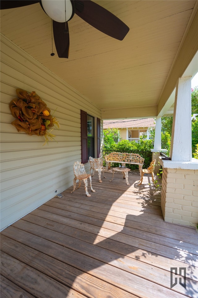 wooden deck featuring covered porch and ceiling fan