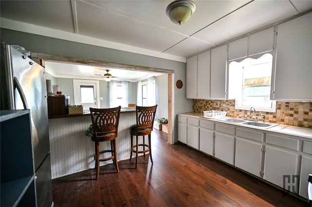 kitchen with a wealth of natural light, dark wood-type flooring, and white cabinetry