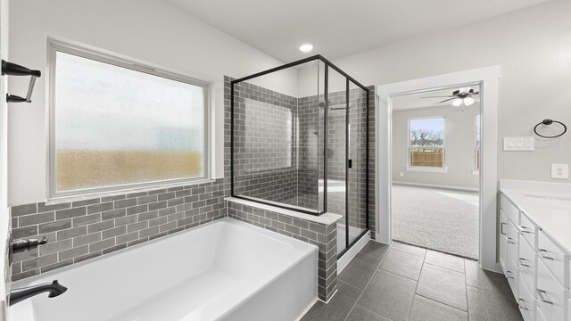 bathroom featuring tile patterned flooring, vanity, ceiling fan, and plus walk in shower