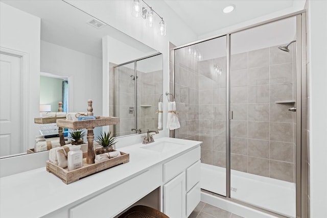 bathroom with tile patterned floors, a shower with shower door, and vanity