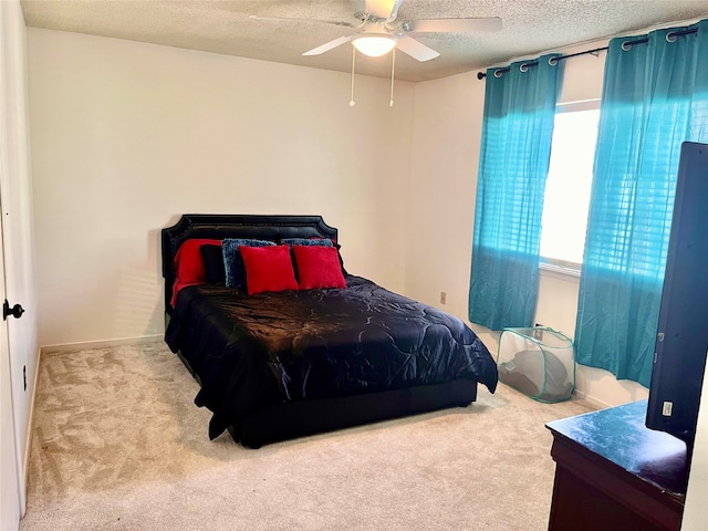 bedroom featuring ceiling fan, light colored carpet, and a textured ceiling