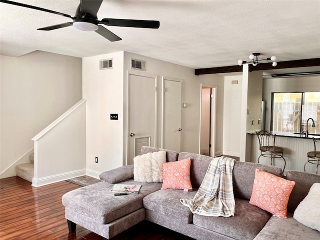 living room featuring a textured ceiling, dark hardwood / wood-style flooring, ceiling fan, and sink