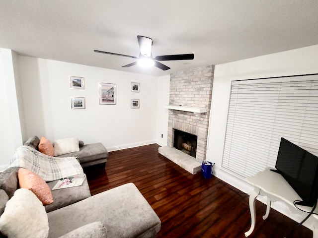 living room featuring ceiling fan, dark hardwood / wood-style floors, and a fireplace