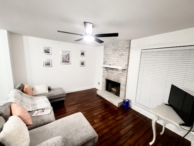 living area with ceiling fan, a fireplace, wood finished floors, and baseboards