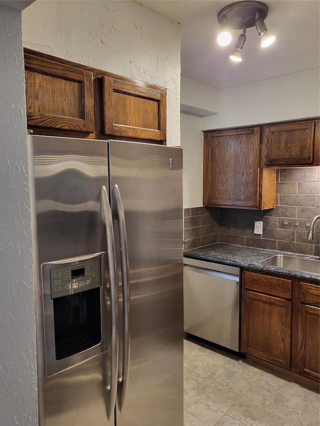 kitchen with appliances with stainless steel finishes, sink, and tasteful backsplash