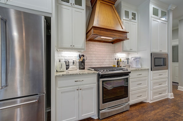 kitchen featuring appliances with stainless steel finishes, custom range hood, dark hardwood / wood-style flooring, and white cabinetry