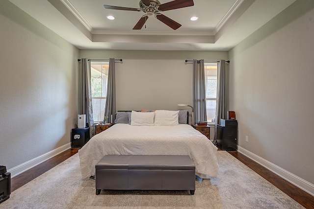 bedroom featuring ceiling fan, hardwood / wood-style flooring, and multiple windows