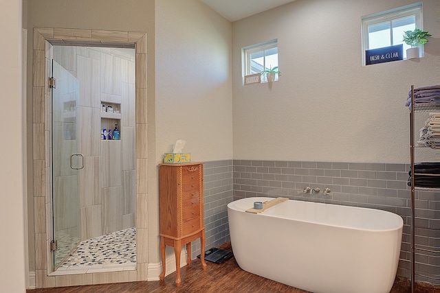 bathroom with separate shower and tub, tile walls, hardwood / wood-style flooring, and a wealth of natural light