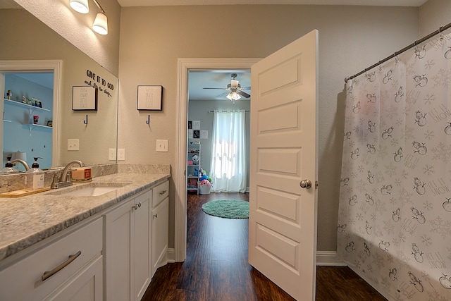 bathroom with wood-type flooring, vanity, ceiling fan, and shower / tub combo