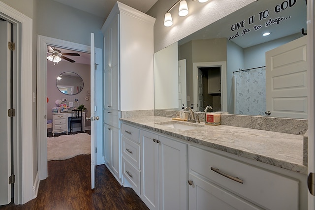 bathroom with a shower with shower curtain, hardwood / wood-style floors, ceiling fan, and vanity