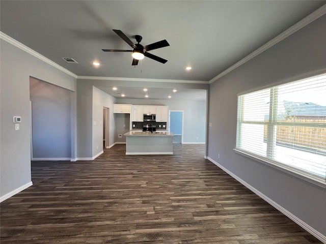 102 Levi Dr, Cleburne, TX 76031 - kitchen featuring stainless steel microwave, crown molding, a ceiling fan, white cabinets, and backsplash