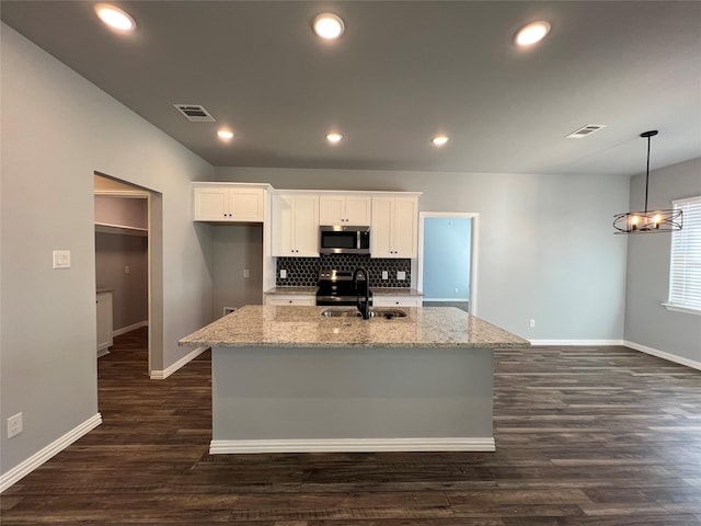 102 Levi Dr, Cleburne, TX 76031 - kitchen with appliances with stainless steel finishes, a sink, baseboards, white cabinets, and a kitchen island with sink