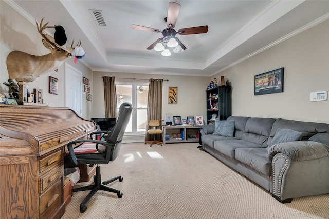 carpeted office with a tray ceiling, ceiling fan, and crown molding