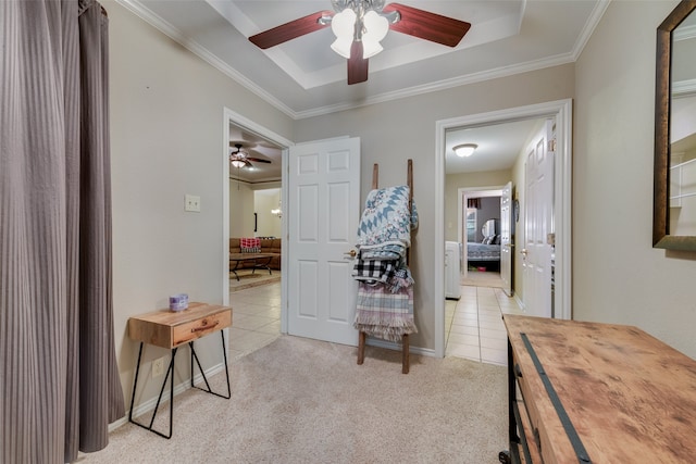 corridor featuring a tray ceiling, light colored carpet, and ornamental molding