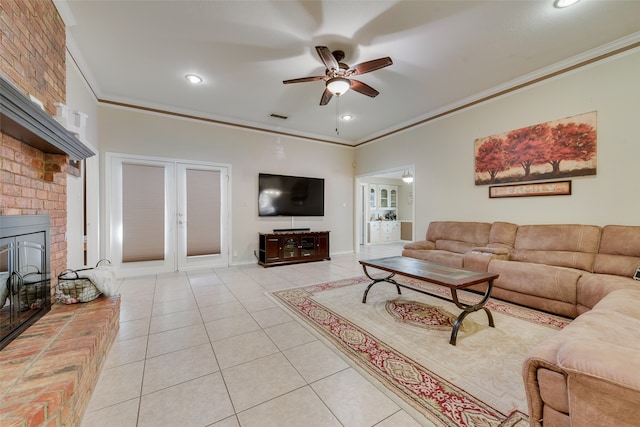 living room with ceiling fan, light tile patterned flooring, ornamental molding, and a fireplace